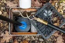Homeowner performing routine maintenance on drainage systems in a garden setting