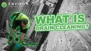 Professional drainage engineer inspecting a drainage system outdoors